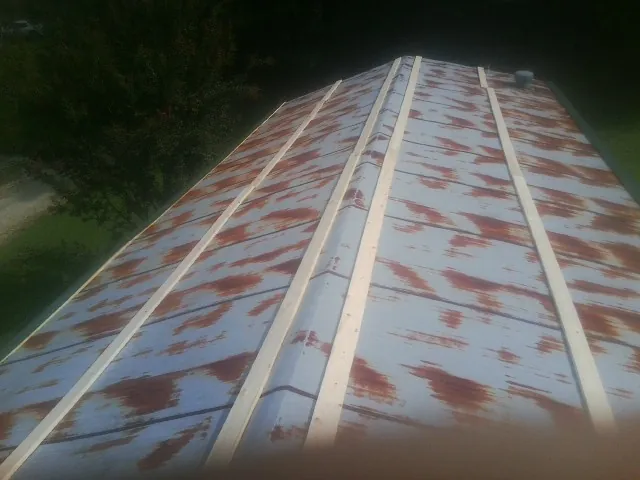 Rusted metal roof panels with new wood purlins before replacement — Storm Damage Roof Repair in Crownsville by Roofing Brothers