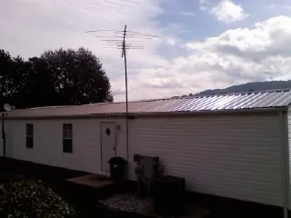 New metal roof on a single wide mobile home with a TV antenna in Crownsville