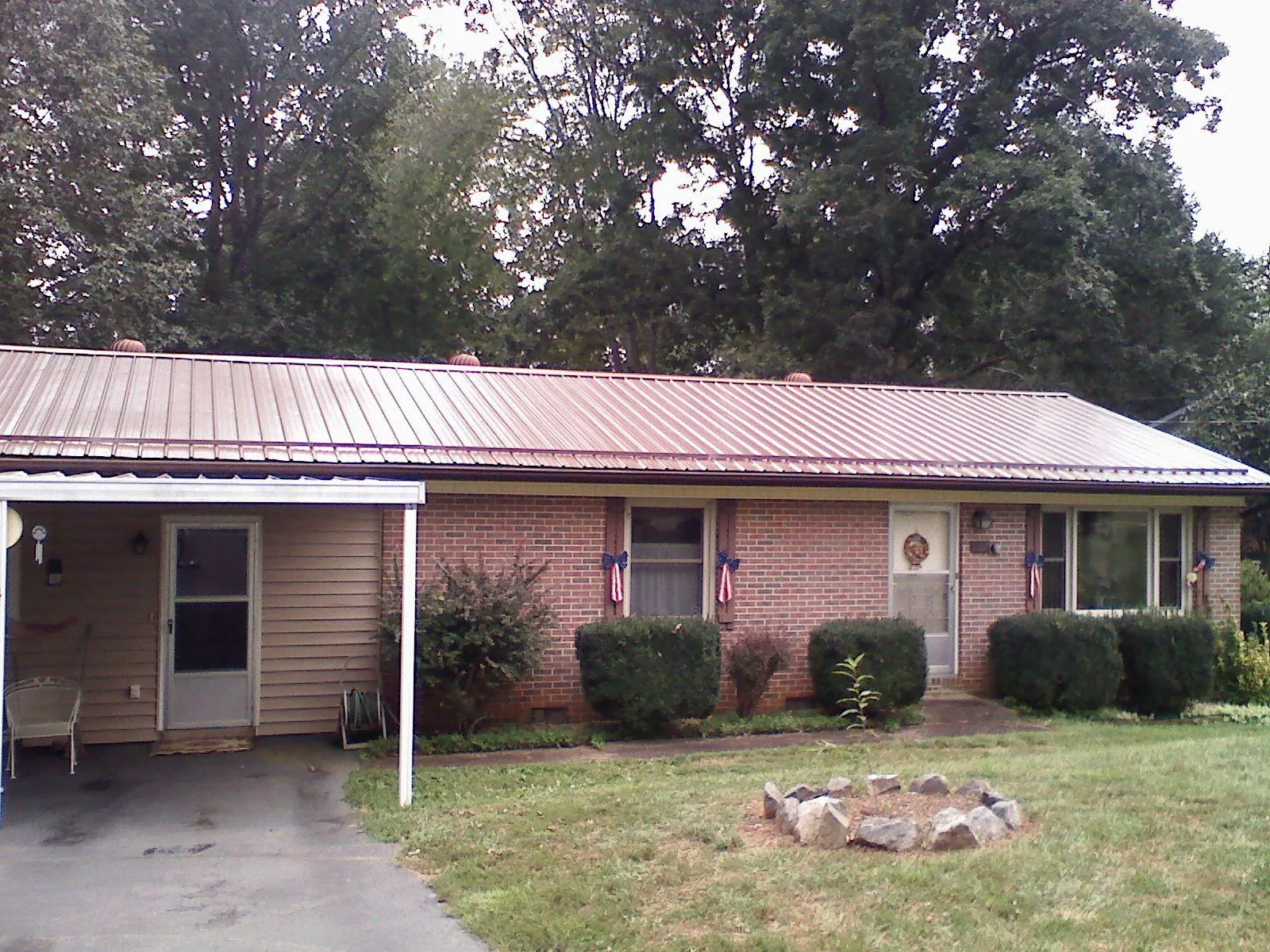 Bronze metal roof and carport on a brick ranch home — Roof Repair work by our crew in Crownsville
