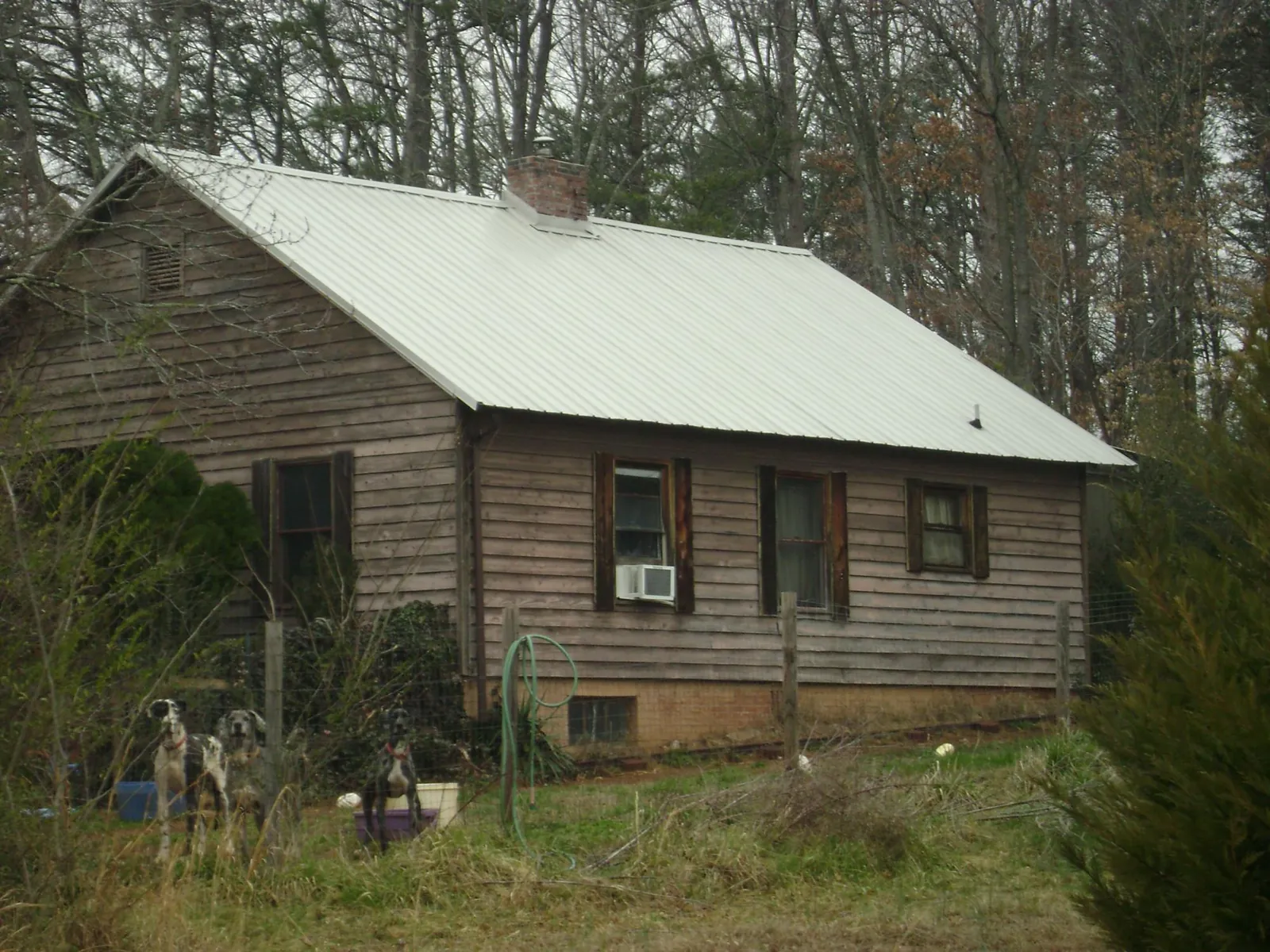 White metal roof on an old wood sided farmhouse, from a Metal Roof Installation job in Crownsville